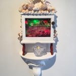 Out of balance, 2017, 37x25x12, repurposed wooden box, velvet, oil on glass, shells, faux pearls, LED lights, napkin ring, fimo, brass knob